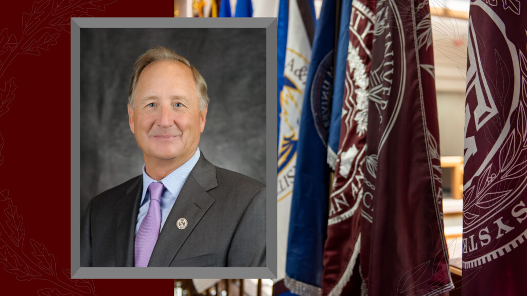 Photo of Robert Albritton with a photo of System office flags behind his photo on the right.
