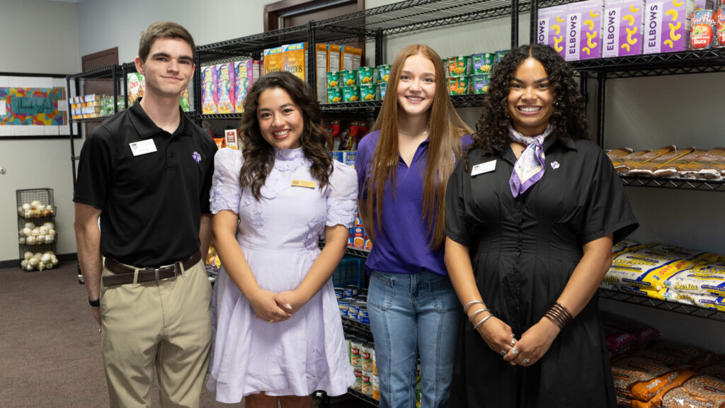 Student Regent Lisa Cantu stands with Tarleton State University student leaders in a campus food pantry surrounded by shelves stocked with pantry items as part of the Stocked for Success campaign.