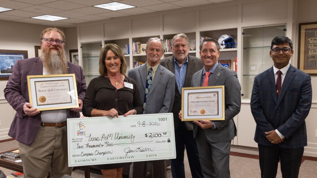 Representatives of The WHIT Program and The Texas A&M University System pose with award certificates and a ceremonial $2,000 check recognizing Texas A&M University as the WHIT Program Campus Champions Large University Award winner for recruiting volunteer tutors for children in foster care.